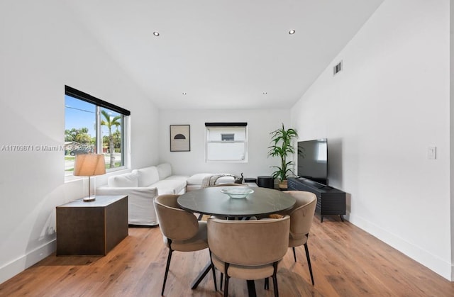 dining area featuring light hardwood / wood-style floors and lofted ceiling