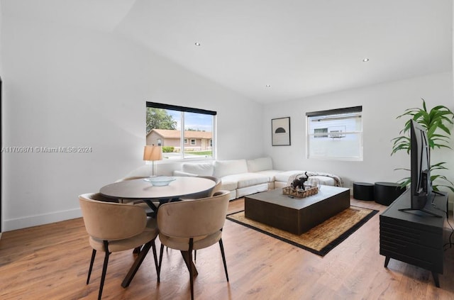 living room featuring light hardwood / wood-style floors and vaulted ceiling