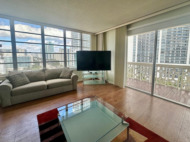 unfurnished living room with expansive windows, a textured ceiling, and hardwood / wood-style flooring