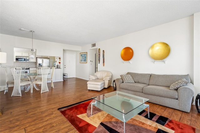 living room with wood-type flooring and a textured ceiling