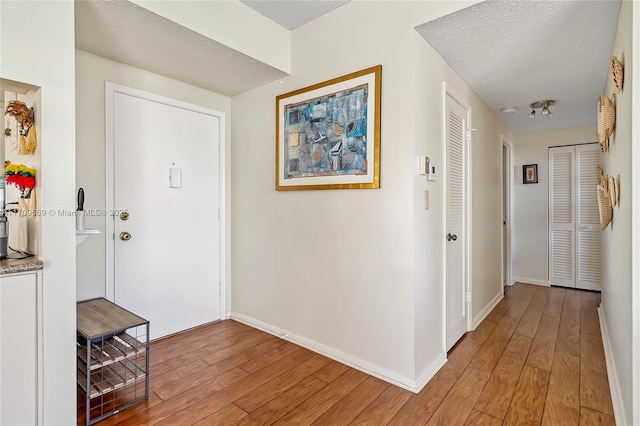 entryway with hardwood / wood-style flooring and a textured ceiling