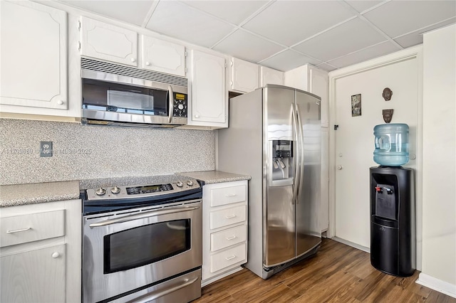 kitchen with white cabinetry, backsplash, stainless steel appliances, and dark hardwood / wood-style floors