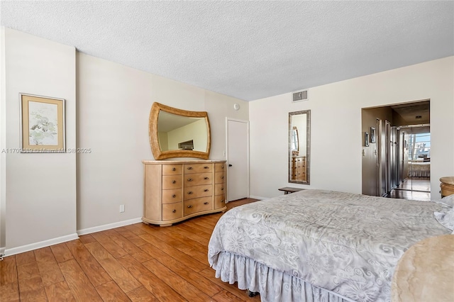 bedroom with hardwood / wood-style flooring and a textured ceiling