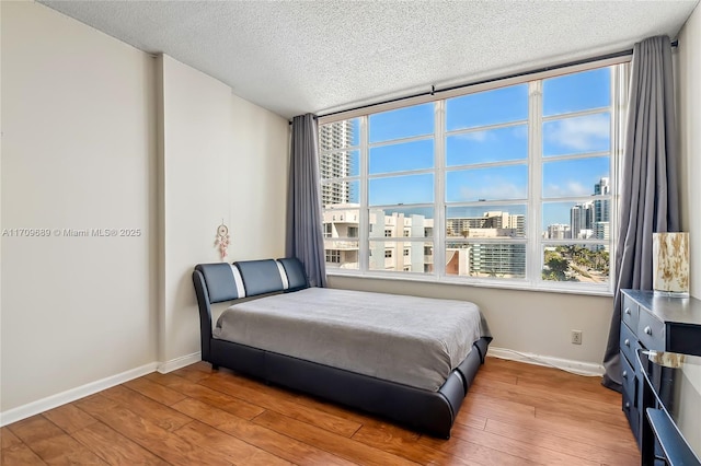 bedroom with light hardwood / wood-style flooring and a textured ceiling