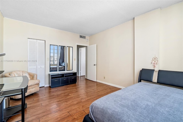 bedroom featuring dark hardwood / wood-style floors and a textured ceiling