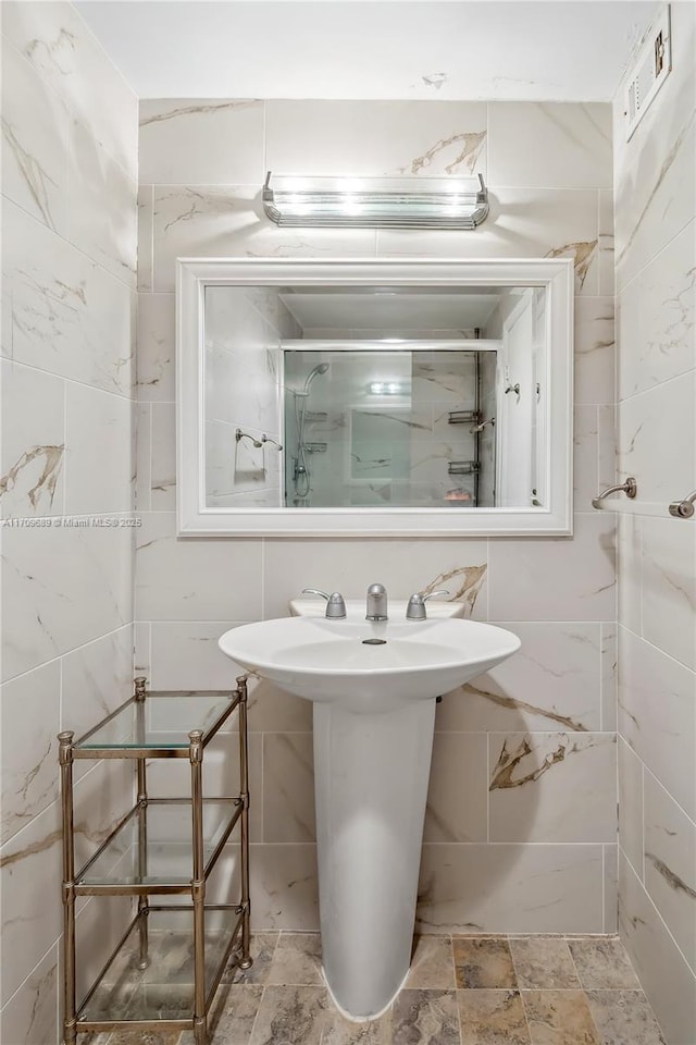 bathroom featuring tile walls and an enclosed shower