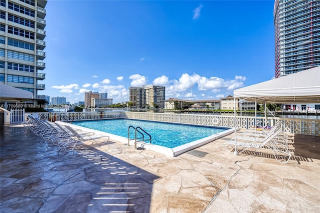 view of swimming pool with a gazebo, a water view, and a patio area