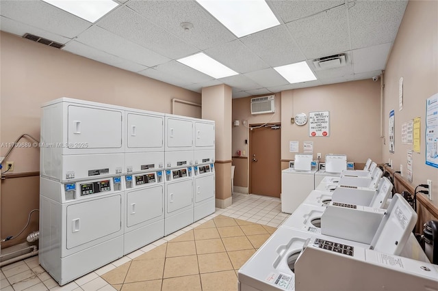 clothes washing area with light tile patterned flooring, washing machine and clothes dryer, stacked washer / dryer, and a wall mounted air conditioner