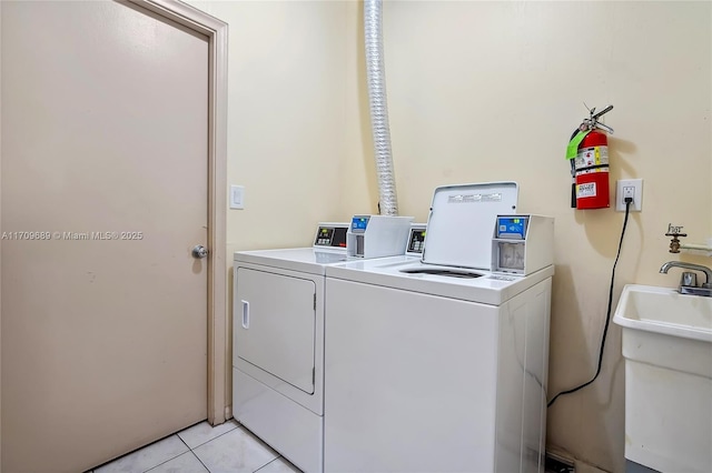 laundry room featuring separate washer and dryer, sink, and light tile patterned flooring