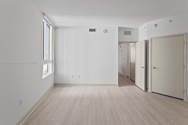 spare room with light hardwood / wood-style flooring