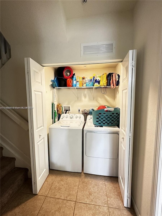 washroom with light tile patterned floors and washing machine and clothes dryer