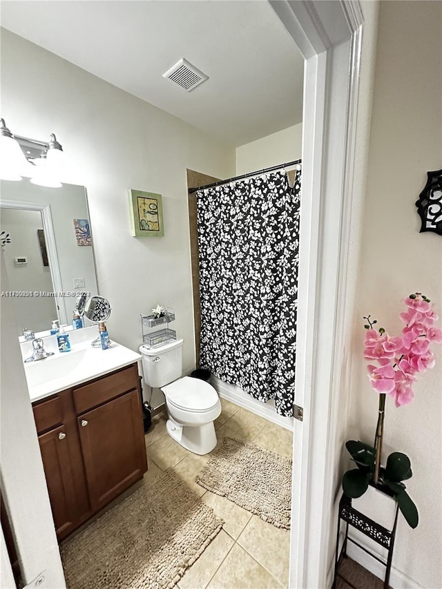 bathroom featuring tile patterned floors, vanity, curtained shower, and toilet