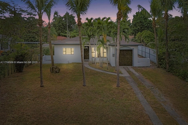 view of front of house with a garage and a yard