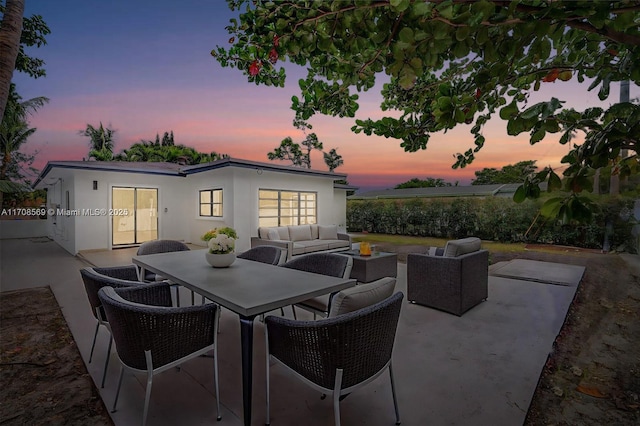 patio terrace at dusk featuring an outdoor living space