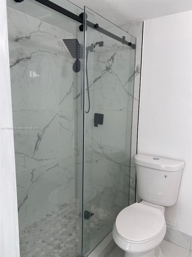 bathroom featuring an enclosed shower and toilet