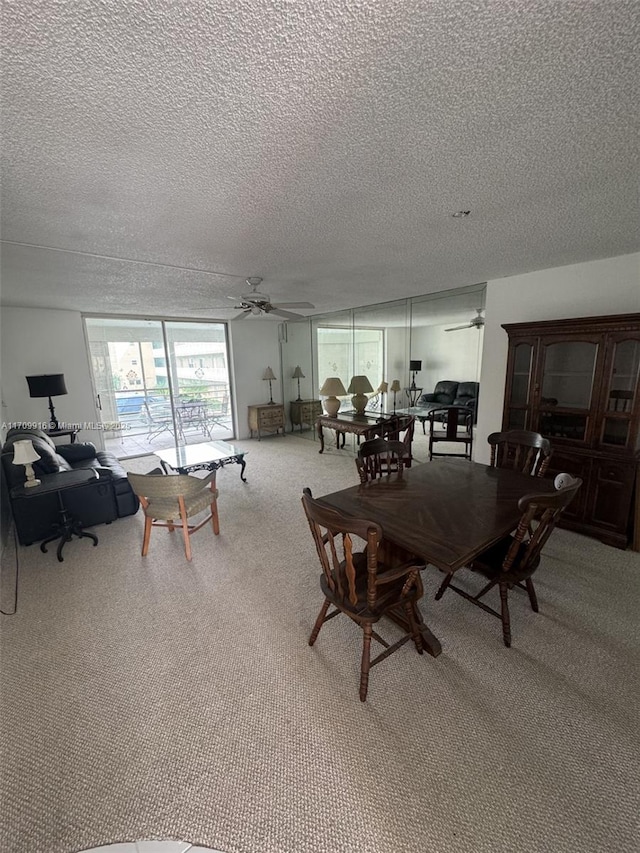 carpeted dining space with ceiling fan and a textured ceiling