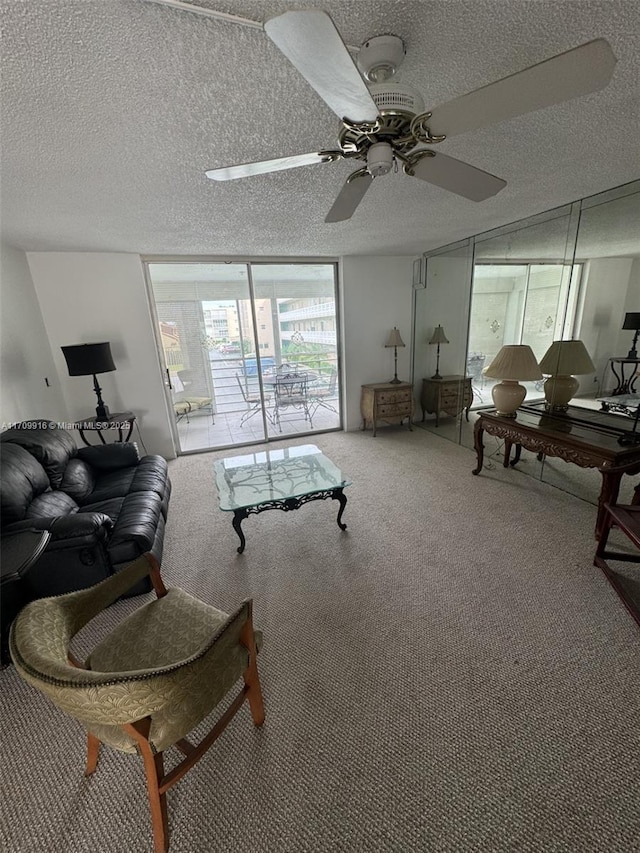 carpeted living room featuring a ceiling fan, expansive windows, and a textured ceiling