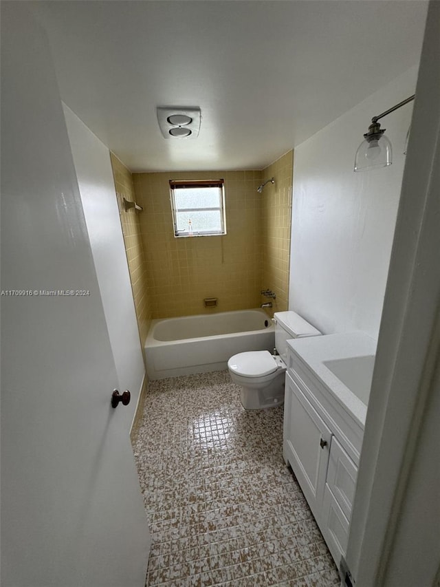 full bathroom with vanity, tiled shower / bath combo, and toilet