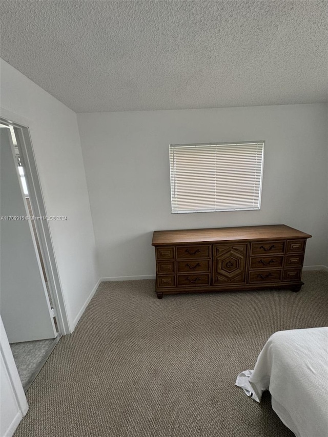 bedroom featuring light carpet and a textured ceiling