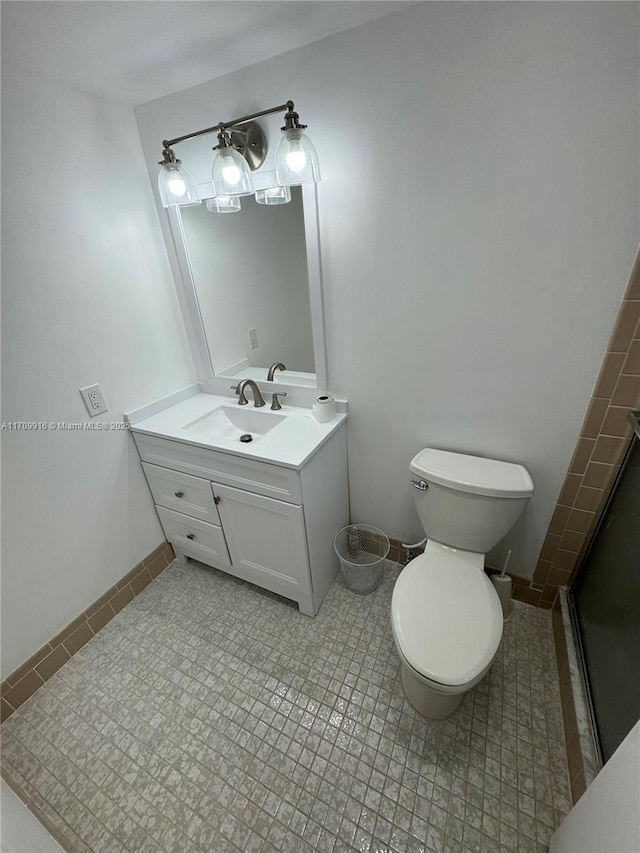 bathroom featuring tile patterned flooring, baseboards, vanity, and toilet