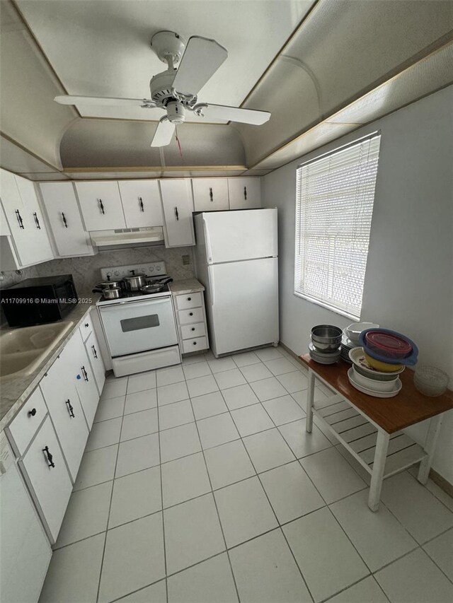 kitchen featuring light tile patterned floors, white appliances, white cabinetry, and sink