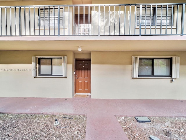 view of exterior entry featuring a balcony