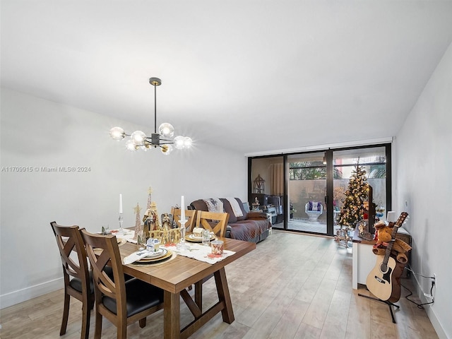 dining space with a notable chandelier, light hardwood / wood-style floors, and floor to ceiling windows