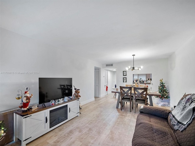 living room featuring light hardwood / wood-style floors and an inviting chandelier