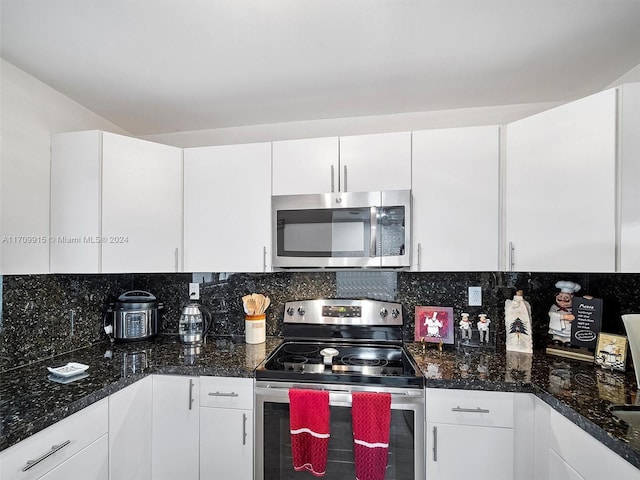 kitchen with backsplash, white cabinetry, dark stone counters, and appliances with stainless steel finishes