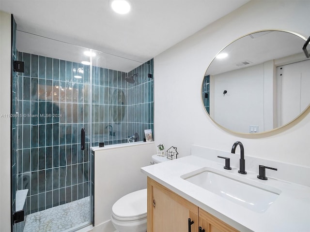 bathroom featuring vanity, toilet, and a shower with shower door