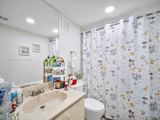 bathroom with walk in shower, vanity, and toilet