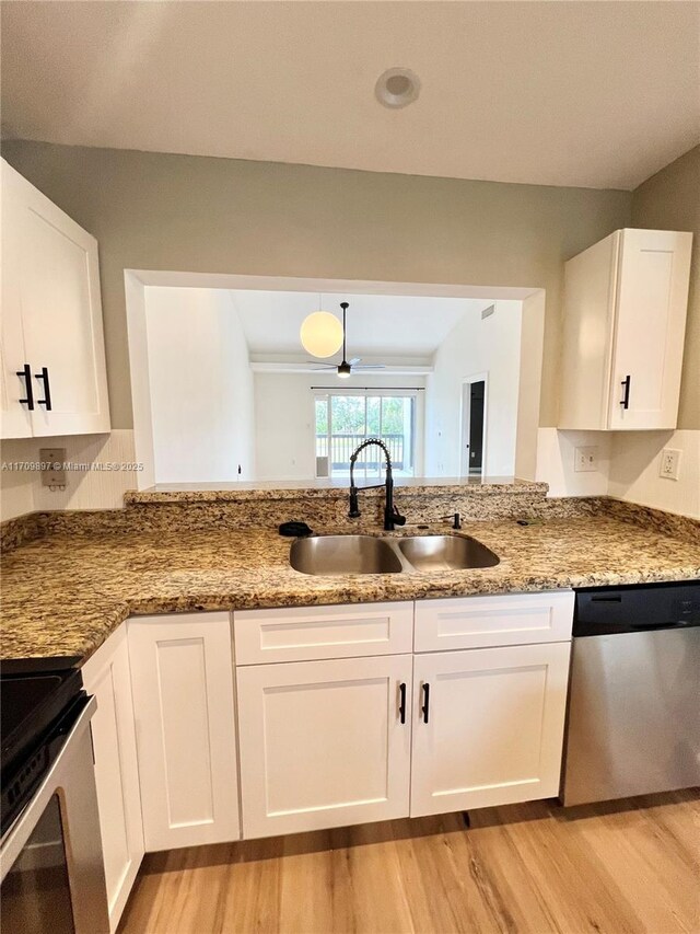 kitchen with appliances with stainless steel finishes, dark stone countertops, white cabinetry, and sink