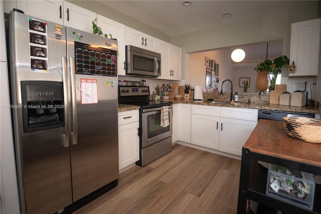 kitchen with white cabinetry, sink, dark stone counters, and appliances with stainless steel finishes