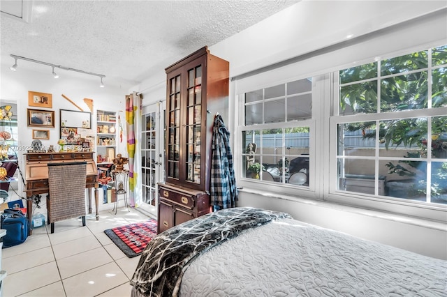 tiled bedroom featuring a textured ceiling