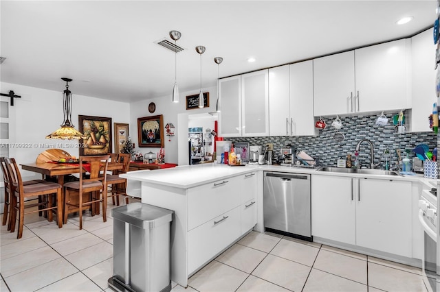 kitchen with kitchen peninsula, sink, dishwasher, white cabinetry, and hanging light fixtures