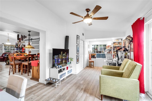 living room featuring ceiling fan, lofted ceiling, and hardwood / wood-style flooring