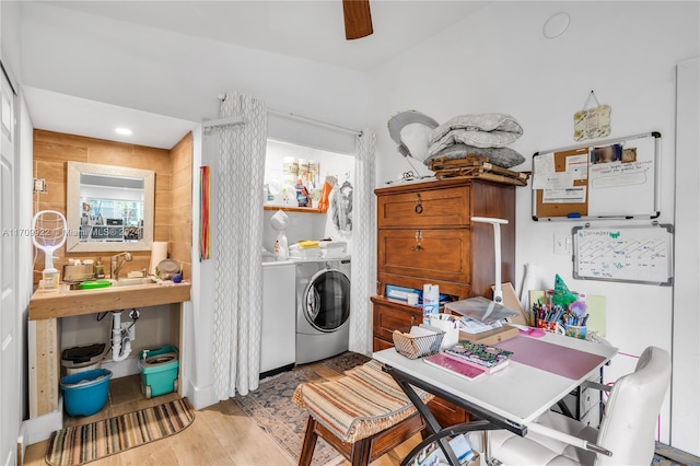 laundry area with separate washer and dryer, sink, and light hardwood / wood-style floors