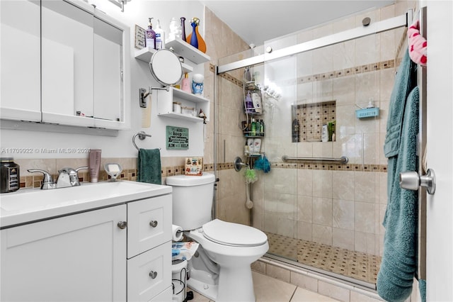 bathroom featuring tile patterned flooring, vanity, toilet, and an enclosed shower