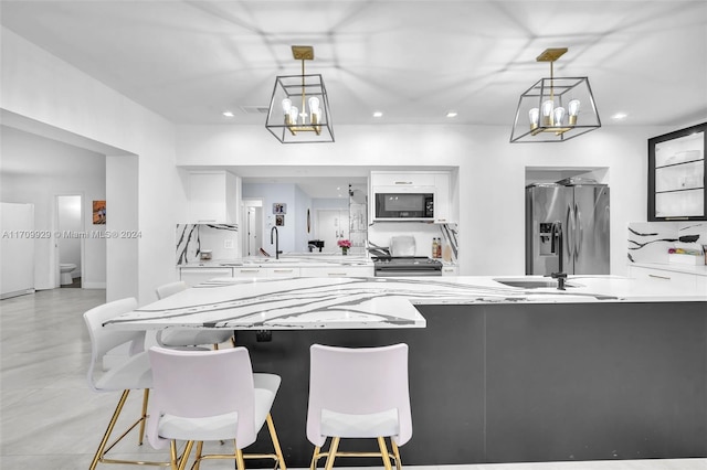 kitchen featuring pendant lighting, white cabinets, a kitchen breakfast bar, appliances with stainless steel finishes, and kitchen peninsula