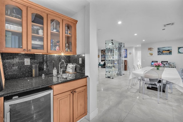 bar featuring decorative backsplash, wine cooler, dark stone counters, and sink