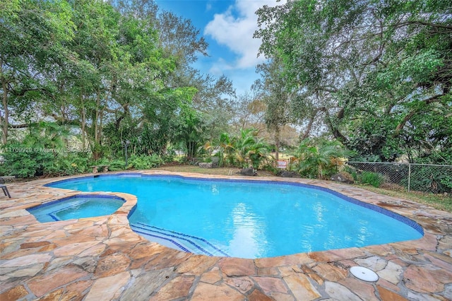 view of pool with an in ground hot tub and a patio