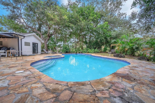 view of swimming pool featuring an in ground hot tub and a patio