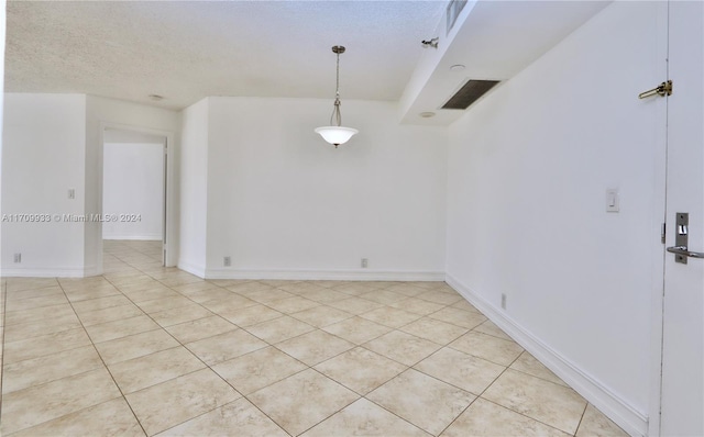 unfurnished room with light tile patterned flooring and a textured ceiling