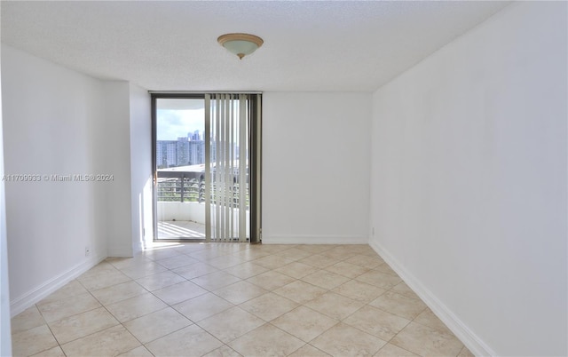 tiled empty room with a textured ceiling