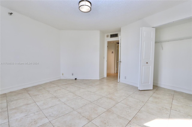 unfurnished bedroom with a closet and a textured ceiling