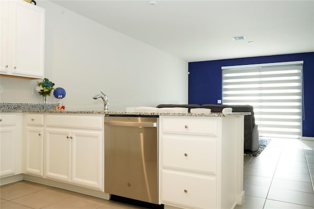 kitchen featuring kitchen peninsula, light tile patterned floors, stainless steel dishwasher, and light stone counters