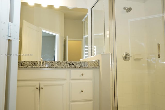 bathroom featuring vanity and a shower with door