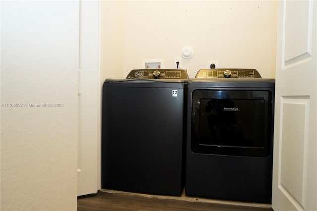 laundry area with washer and clothes dryer and dark wood-type flooring