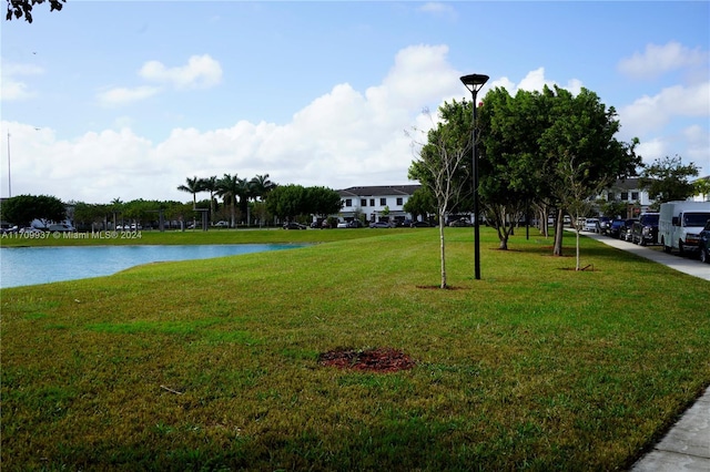 surrounding community with a lawn and a water view