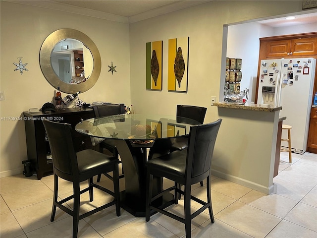 dining room featuring crown molding and light tile patterned flooring